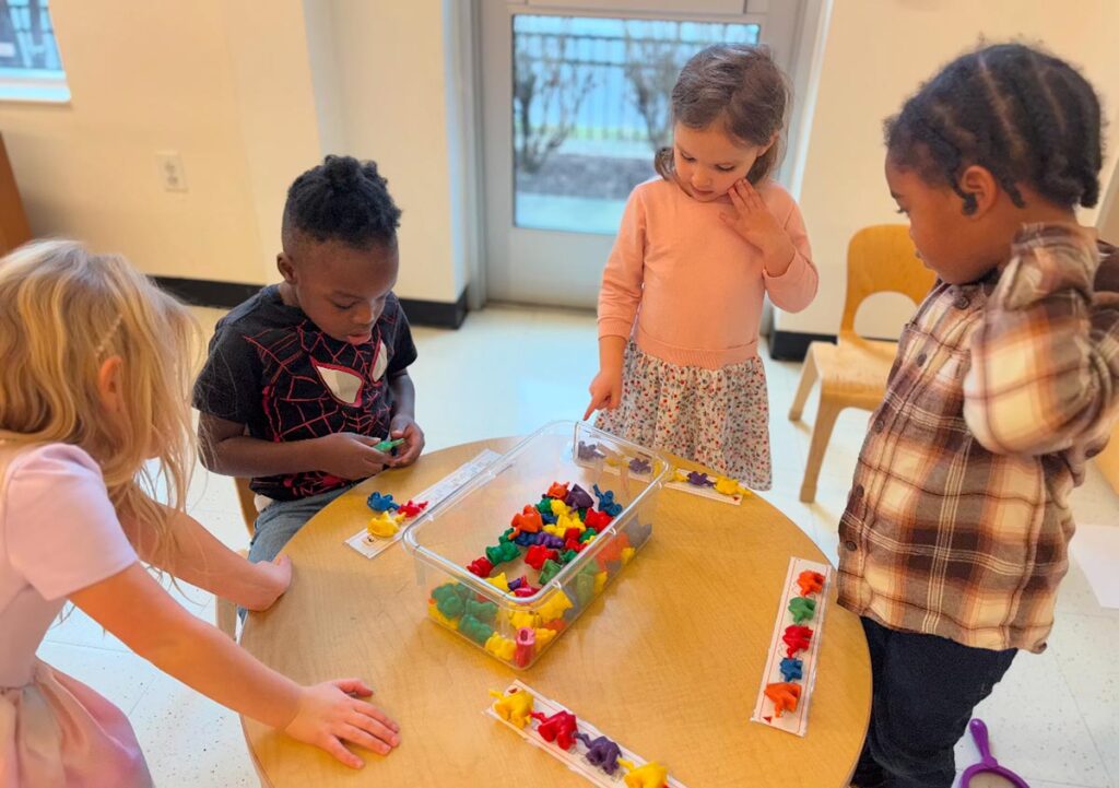 Kids around table at E3 School working on math skills