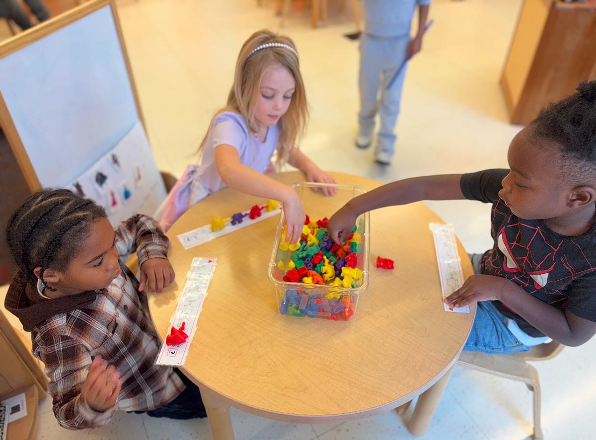 Kids around table at E3 School working on math skills